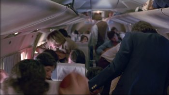 Movie still from “Alive” (1993), directed by Frank Marshall – A group of people on an airplane in the middle of the day; Medium shot, Low angle