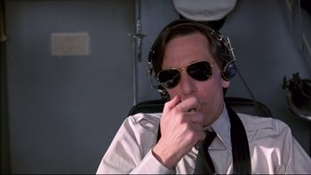 Movie still from “Alive” (1993), directed by Frank Marshall – A man wearing sunglasses and a tie and headphones; Medium shot, Low angle