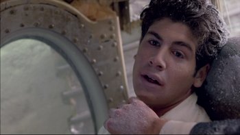 Movie still from “Alive” (1993), directed by Frank Marshall – A young man holding something in his hands; Close Up shot, High angle