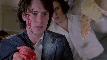 Movie still from “Alive” (1993), directed by Frank Marshall – A man in a suit with blood all over his face; Close Up shot, Low angle