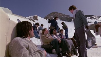 Movie still from “Alive” (1993), directed by Frank Marshall – A group of people sitting in the snow on top of a mountain; Wide shot, High angle