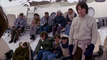 Movie still from “Alive” (1993), directed by Frank Marshall – A group of people sitting on the back of an airplane; Wide shot, High angle