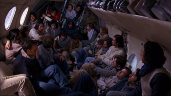 Movie still from “Alive” (1993), directed by Frank Marshall – A group of people sitting on top of an airplane; Wide shot, Overhead angle