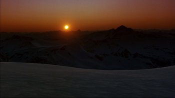 Movie still from “Alive” (1993), directed by Frank Marshall – The sun is setting over a mountain range; Extreme Wide shot, High angle