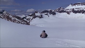 Movie still from “Alive” (1993), directed by Frank Marshall – A person sitting in the snow on top of a mountain; Extreme Wide shot, High angle