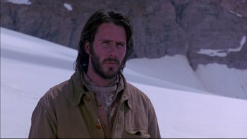 Movie still from “Alive” (1993), directed by Frank Marshall – A man with long hair is standing in the snow; Close Up shot, Low angle