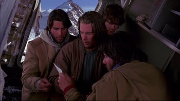 Movie still from “Alive” (1993), directed by Frank Marshall – A group of men sitting on top of an airplane; Medium shot, Low angle