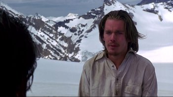 Movie still from “Alive” (1993), directed by Frank Marshall – A man standing in front of a snowy mountain; Close Up shot, Over the shoulder angle