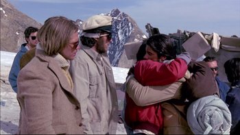 Movie still from “Alive” (1993), directed by Frank Marshall – A group of people standing next to each other on top of a mountain; Medium shot, Low angle