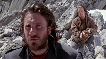 Movie still from “Alive” (1993), directed by Frank Marshall – A man with long hair sitting next to another man with long hair; Close Up shot, Low angle