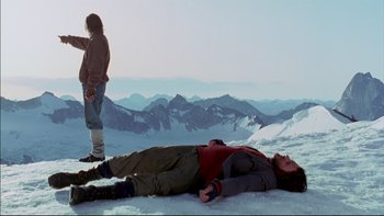 Movie still from “Alive” (1993), directed by Frank Marshall – A man laying on top of a snow covered slope; Wide shot, Low angle