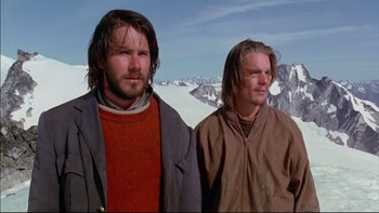 Movie still from “Alive” (1993), directed by Frank Marshall – Two men standing next to each other on top of a mountain; Medium shot, Low angle