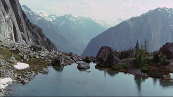 Movie still from “Alive” (1993), directed by Frank Marshall – A view of a mountain range with a lake in the foreground; Extreme Wide shot, High angle