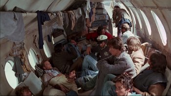 Movie still from “Alive” (1993), directed by Frank Marshall – A group of people sitting on top of an airplane; Wide shot, High angle