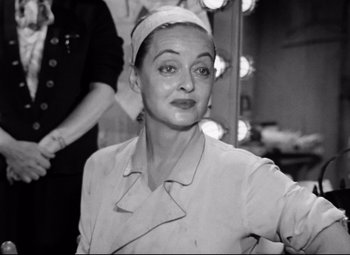 Movie still from “All About Eve” (1950), directed by Joseph L. Mankiewicz – An old photo of a woman in front of a mirror; Close Up shot, Over the shoulder angle
