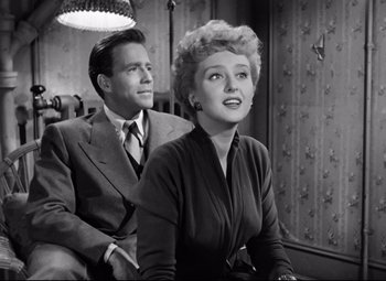 Movie still from “All About Eve” (1950), directed by Joseph L. Mankiewicz – A man and a woman sitting next to each other in a room; Medium shot, Low angle