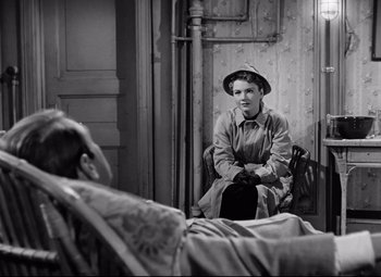 Movie still from “All About Eve” (1950), directed by Joseph L. Mankiewicz – An old photo of a woman sitting in a chair next to a bed; Medium shot, High angle
