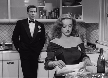 Movie still from “All About Eve” (1950), directed by Joseph L. Mankiewicz – A man and a woman standing in a kitchen preparing a meal; Medium shot, Over the shoulder angle