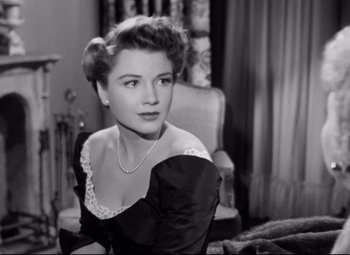 Movie still from “All About Eve” (1950), directed by Joseph L. Mankiewicz – An old black and white photo of a woman sitting in a chair; Close Up shot, Low angle