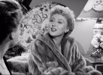 Movie still from “All About Eve” (1950), directed by Joseph L. Mankiewicz – An old photo of a woman wearing a fur coat; Close Up shot, Over the shoulder angle