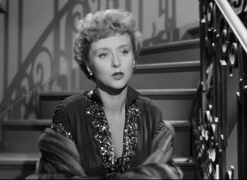 Movie still from “All About Eve” (1950), directed by Joseph L. Mankiewicz – A black - and - white photo of a woman sitting on some stairs; Close Up shot, Low angle