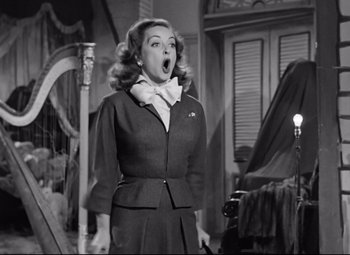 Movie still from “All About Eve” (1950), directed by Joseph L. Mankiewicz – A woman with a surprised look on her face; Medium shot, Low angle