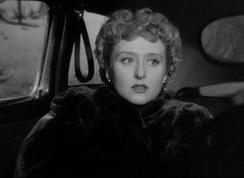 Movie still from “All About Eve” (1950), directed by Joseph L. Mankiewicz – An old photo of a woman sitting in the back of a car; Close Up shot, High angle