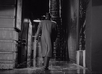 Movie still from “All About Eve” (1950), directed by Joseph L. Mankiewicz – A black and white photo of a man walking down a staircase; Wide shot, Low angle