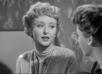 Movie still from “All About Eve” (1950), directed by Joseph L. Mankiewicz – An old photo of an older woman in a suit; Close Up shot, Over the shoulder angle