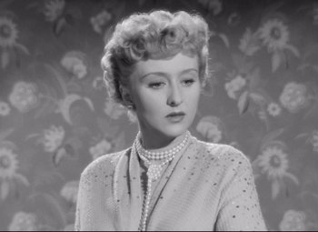 Movie still from “All About Eve” (1950), directed by Joseph L. Mankiewicz – An old photo of an older woman in a sweater; Close Up shot, Low angle