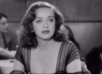 Movie still from “All About Eve” (1950), directed by Joseph L. Mankiewicz – A black and white photo of a woman with long hair; Close Up shot, Over the shoulder angle