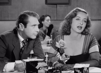 Movie still from “All About Eve” (1950), directed by Joseph L. Mankiewicz – A man and a woman sitting at a table; Close Up shot, Over the shoulder angle