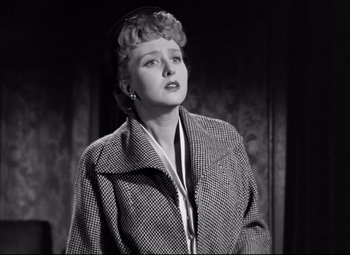 Movie still from “All About Eve” (1950), directed by Joseph L. Mankiewicz – An old photo of a woman in a coat looking up; Medium shot, Low angle