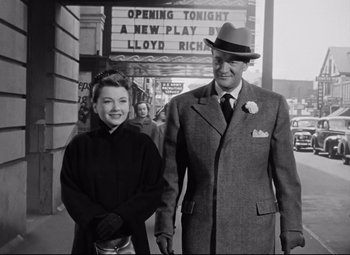 Movie still from “All About Eve” (1950), directed by Joseph L. Mankiewicz – An older man and a young woman standing in front of a theater; Medium shot, Low angle