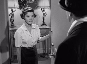 Movie still from “All About Eve” (1950), directed by Joseph L. Mankiewicz – An old photo of a woman standing in front of a man; Medium shot, Over the shoulder angle