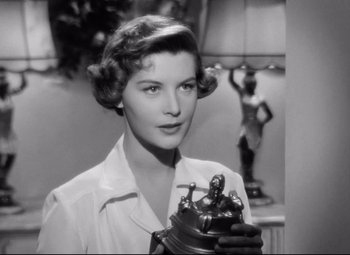 Movie still from “All About Eve” (1950), directed by Joseph L. Mankiewicz – An old photo of a woman holding an antique telephone; Close Up shot, Low angle