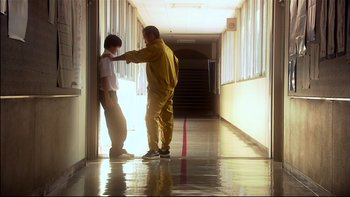 Movie still from “All About Lily Chou-Chou” (2001), directed by Shunji Iwai – A man helping a boy put on a yellow jacket; Wide shot, Low angle