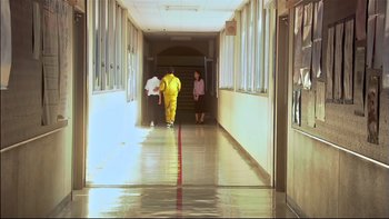 Movie still from “All About Lily Chou-Chou” (2001), directed by Shunji Iwai – A man in a yellow suit is walking down a hallway; Extreme Wide shot, Low angle