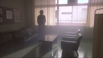 Movie still from “All About Lily Chou-Chou” (2001), directed by Shunji Iwai – A person standing in front of a window in a room; Wide shot, Low angle