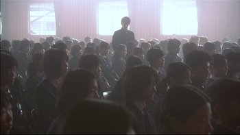 Movie still from “All About Lily Chou-Chou” (2001), directed by Shunji Iwai – A group of people sitting in a large room; Wide shot, High angle