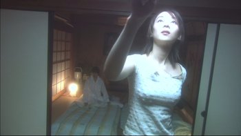 Movie still from “All About Lily Chou-Chou” (2001), directed by Shunji Iwai – A woman standing on top of a bed next to a man; Medium shot, Low angle