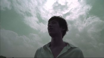Movie still from “All About Lily Chou-Chou” (2001), directed by Shunji Iwai – A man in a white shirt looking up at the sky; Close Up shot, Low angle