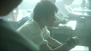 Movie still from “All About Lily Chou-Chou” (2001), directed by Shunji Iwai – A person sitting in a car with a steering wheel; Close Up shot, Low angle