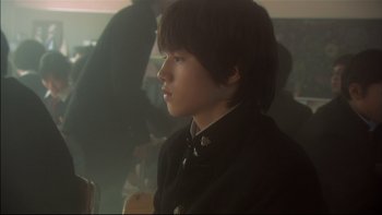 Movie still from “All About Lily Chou-Chou” (2001), directed by Shunji Iwai – A young man in a black jacket is looking to his left; Close Up shot, Over the shoulder angle