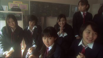 Movie still from “All About Lily Chou-Chou” (2001), directed by Shunji Iwai – A group of young people in school uniforms posing for a picture; Medium shot, High angle