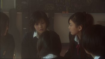 Movie still from “All About Lily Chou-Chou” (2001), directed by Shunji Iwai – Two young women are sitting together in a room; Medium shot, Over the shoulder angle