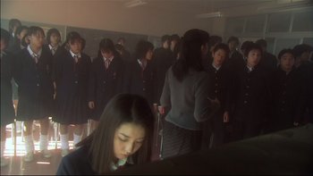 Movie still from “All About Lily Chou-Chou” (2001), directed by Shunji Iwai – A large group of people in a room; Medium shot, High angle