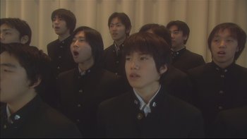Movie still from “All About Lily Chou-Chou” (2001), directed by Shunji Iwai – A group of young men singing in a room; Close Up shot, Low angle