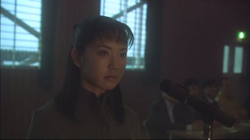 Movie still from “All About Lily Chou-Chou” (2001), directed by Shunji Iwai – A young woman is standing in front of a microphone in a room; Close Up shot, Low angle