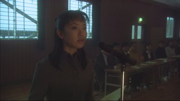 Movie still from “All About Lily Chou-Chou” (2001), directed by Shunji Iwai – A woman standing in front of a microphone in front of a crowd; Close Up shot, Low angle